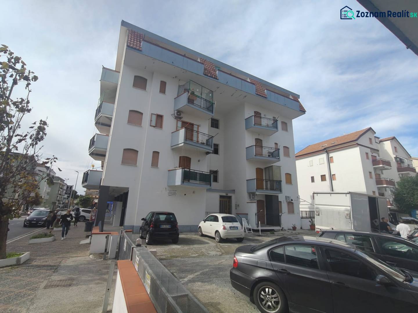 Apartment building in Scalea on 1 Maggio Street with surrounding cars and pedestrians.