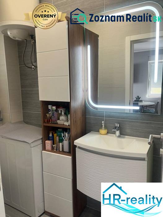 Bathroom in a 3-room apartment with a sink, mirror, and cabinet for toiletries.