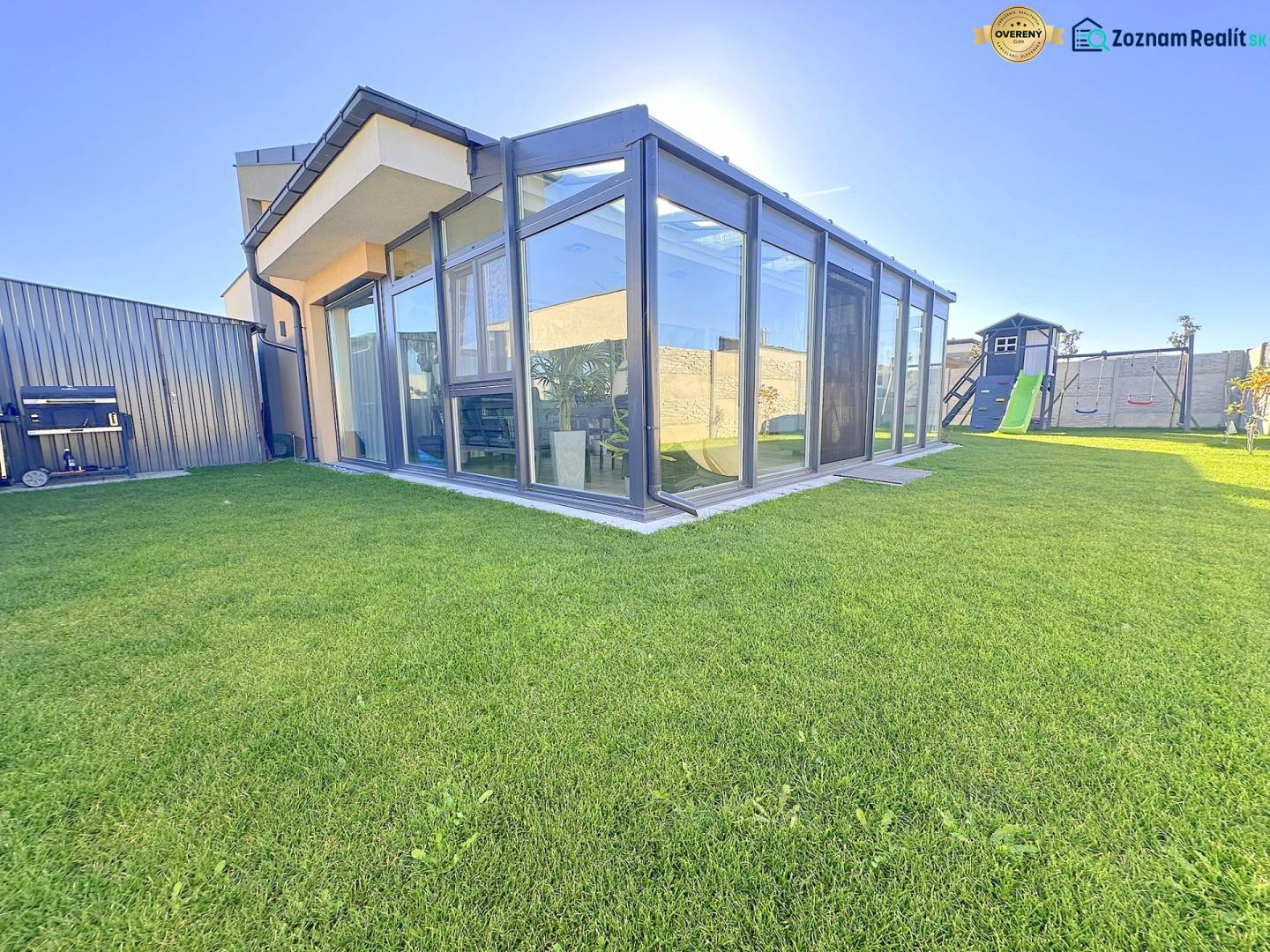 A glazed terrace and a children's playground at a family house in Mosonmagyaróvár.