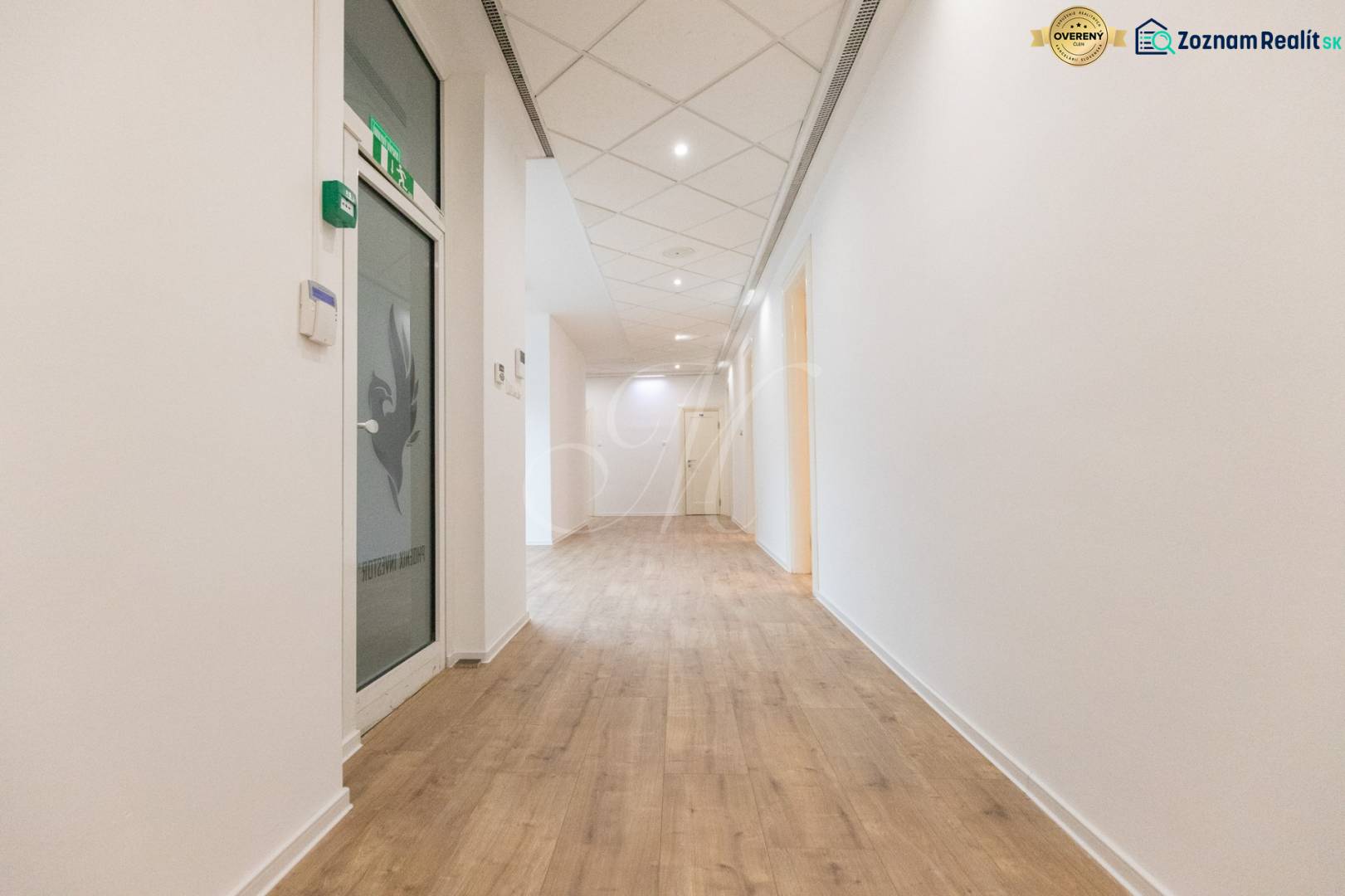 A corridor with a wooden decor floor and white walls in commercial premises.