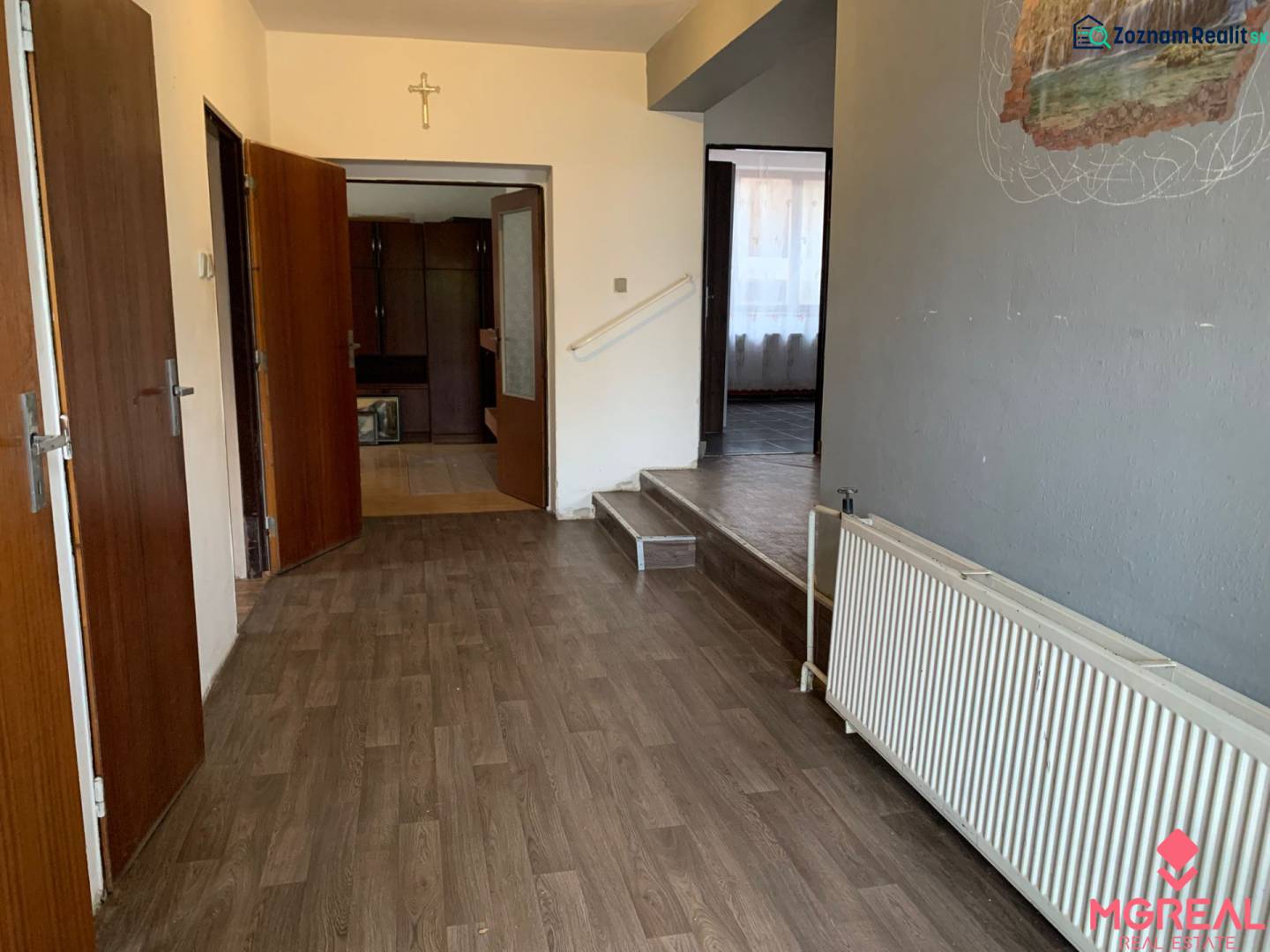 A hallway in a family house with a wooden decor floor and wooden doors.