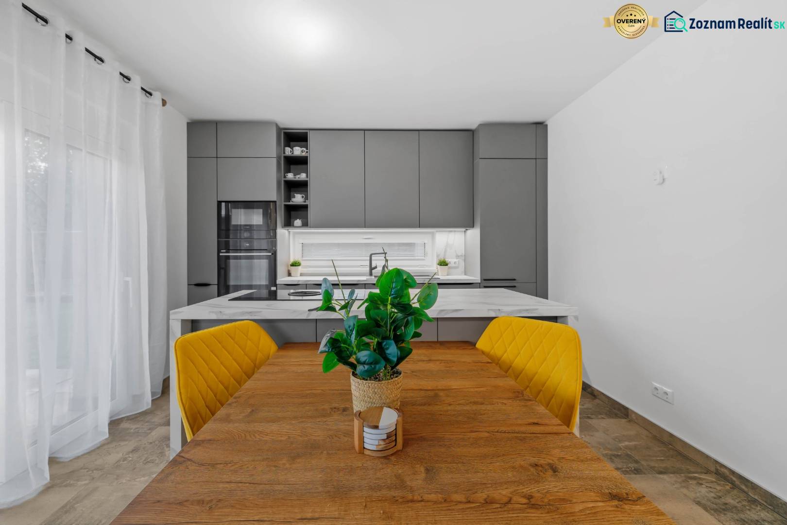 A family house kitchen with a dining table, yellow chairs, and a wooden decor floor.