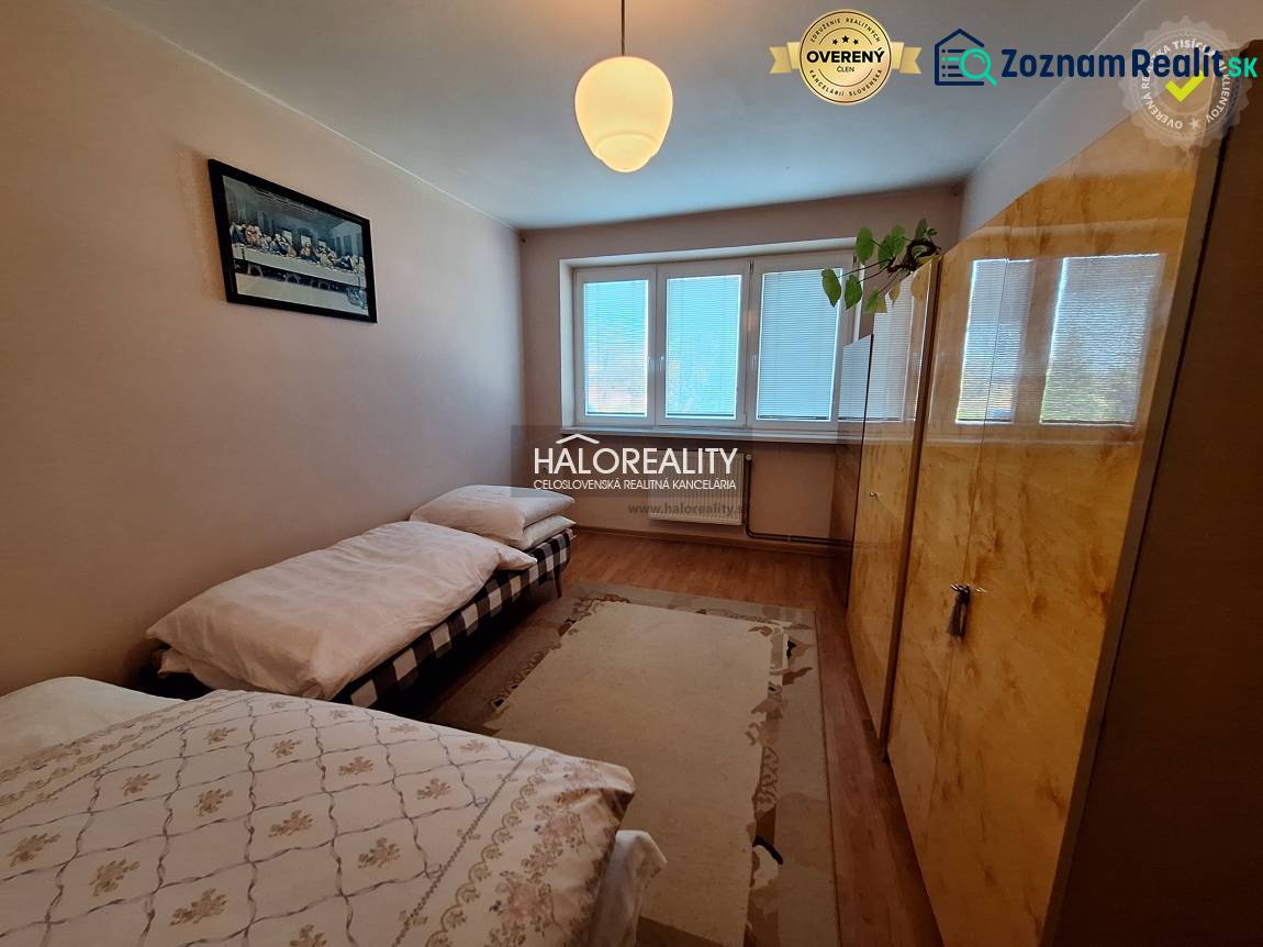 A bedroom with two beds and a wooden decor floor in a three-room apartment.