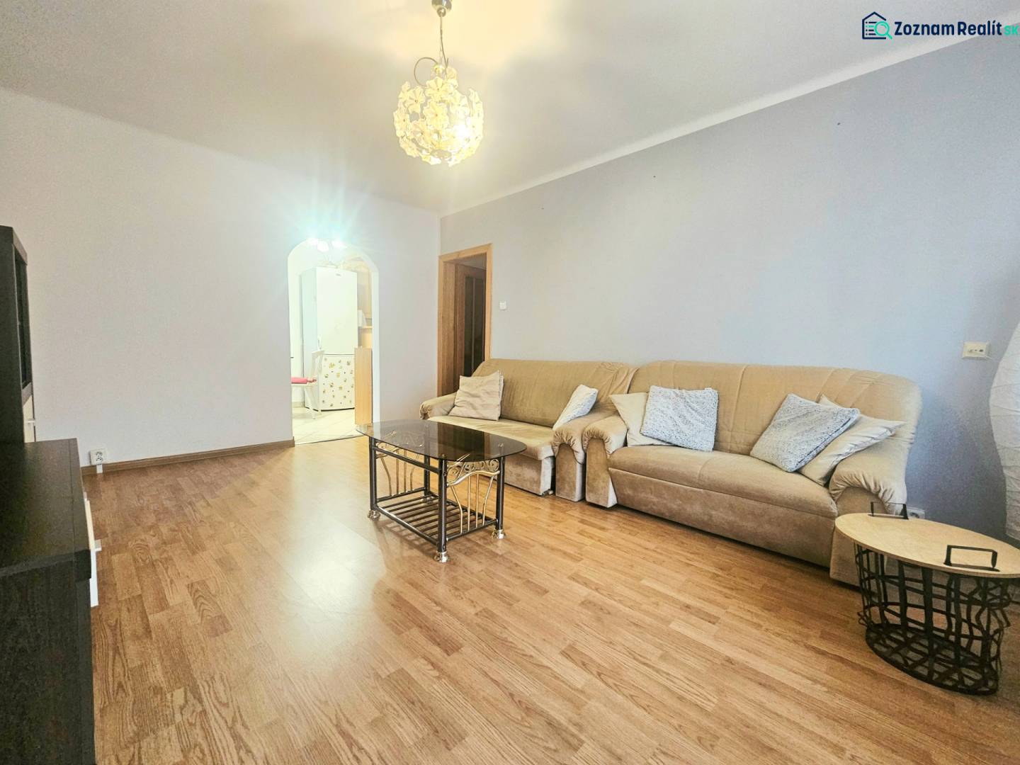 Living room in a 3-room apartment with a beige sofa and a wooden decor floor.