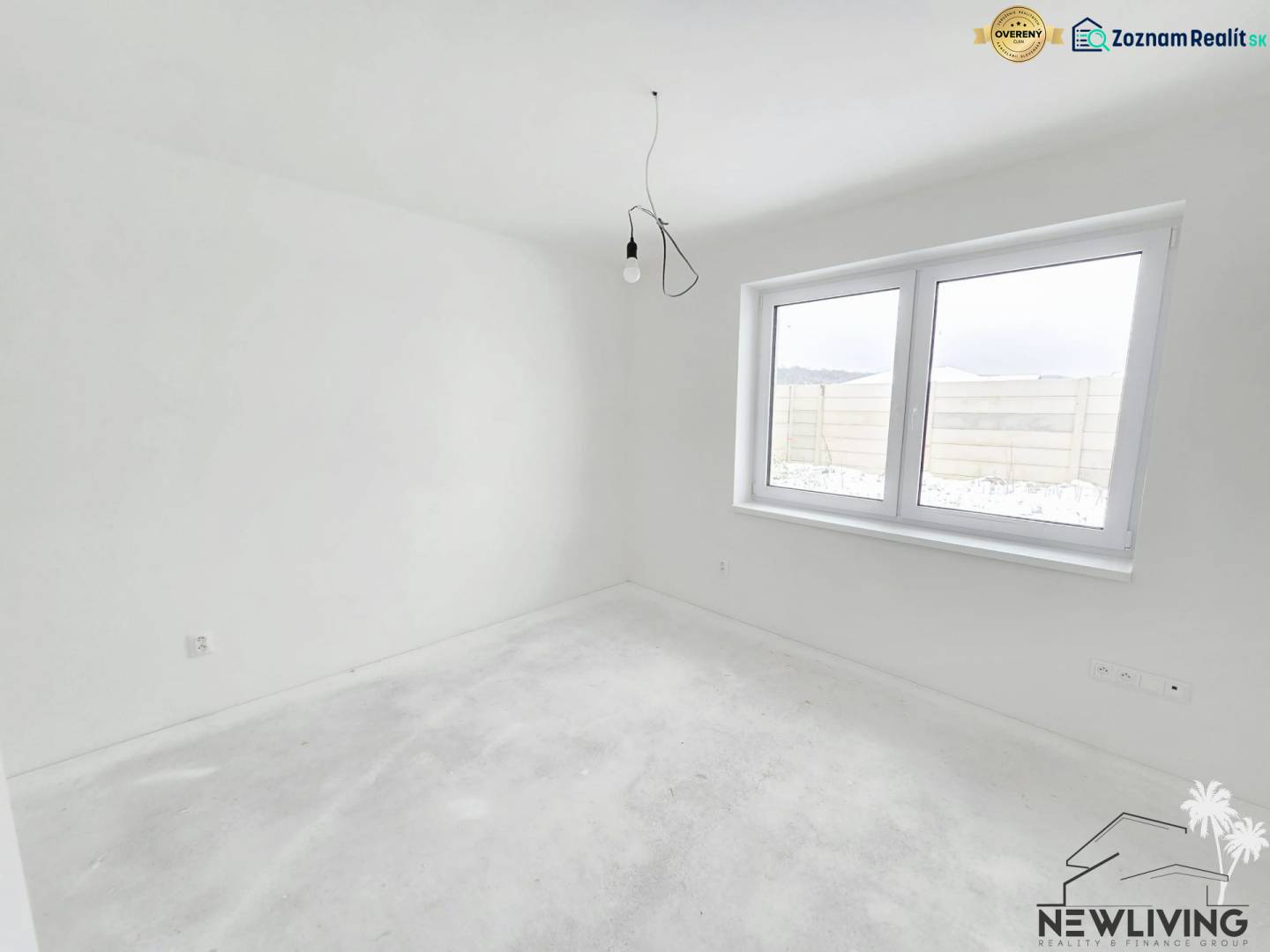 An empty room in a family house with white walls and a large window.