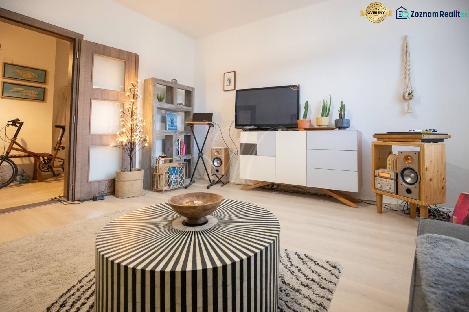 Living room in a two-room apartment with a wooden decor floor, stylish furniture, and decorations.