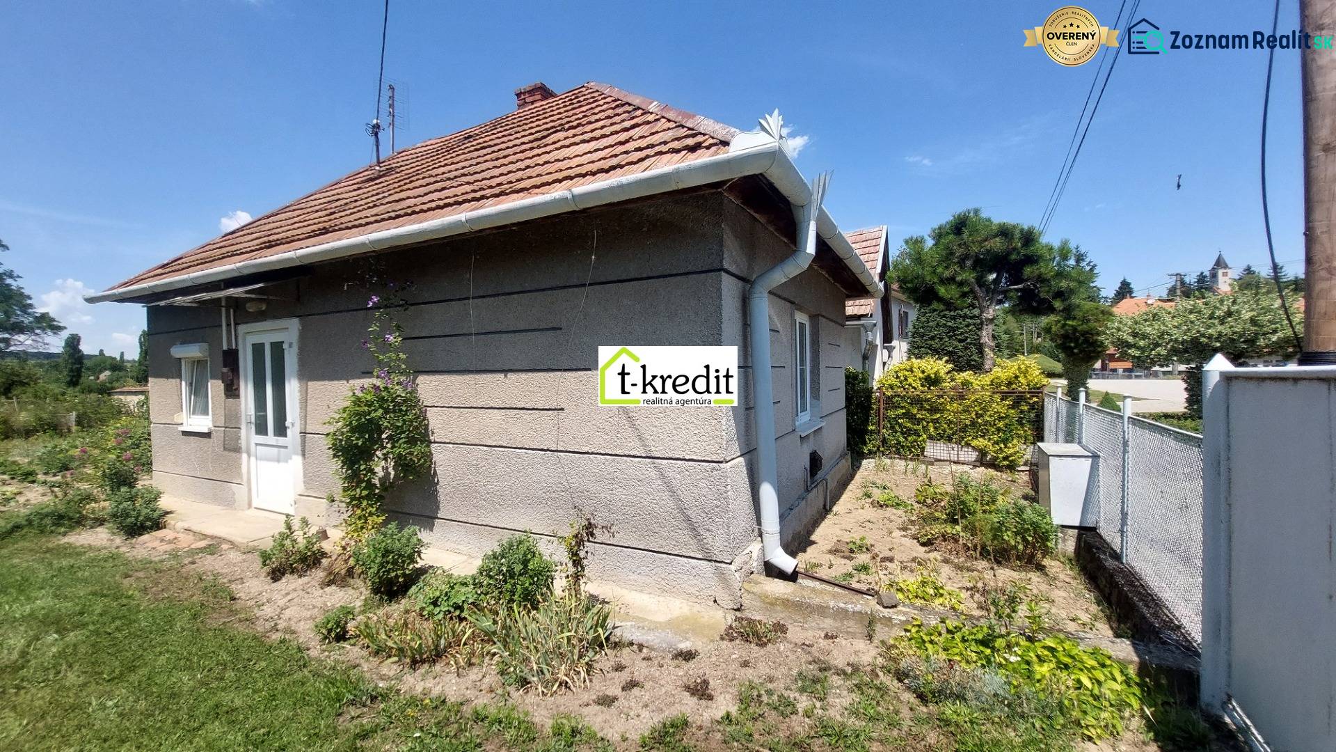 A family house in Nevidzany with a landscaped garden, fencing, and a sloped roof.