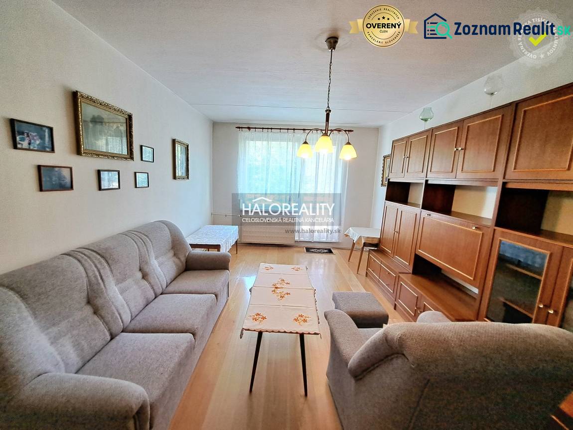Living room with light, wood-patterned flooring, and furniture in a three-room apartment.