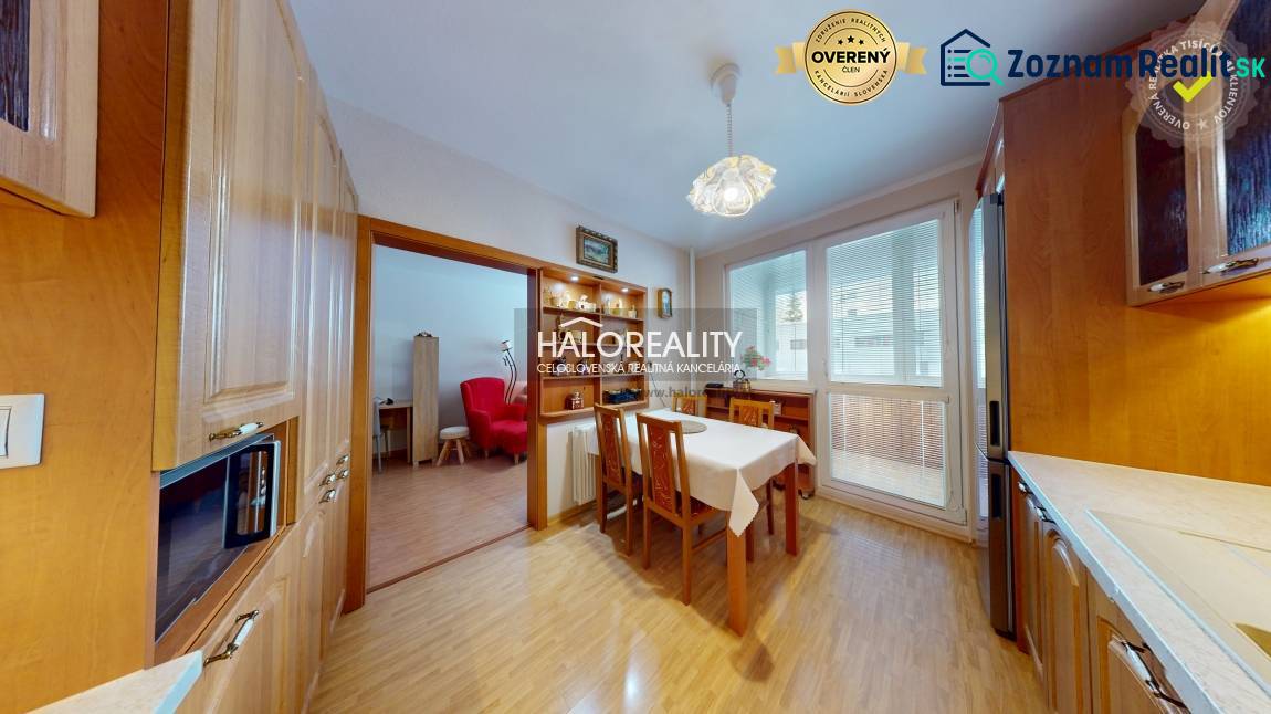 Dining room with kitchen in a two-room apartment. Floor with wood decor, spacious windows.