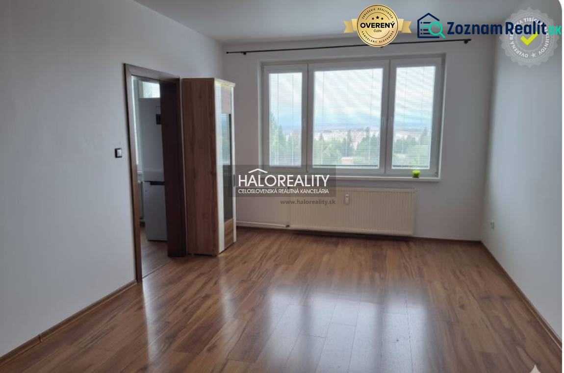 A room with a wooden decor floor and large windows in a 3-room apartment.