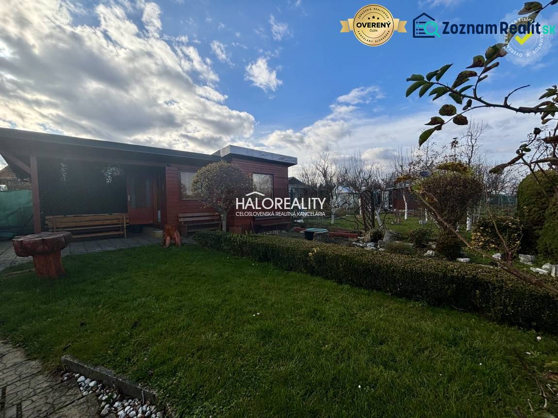 A wooden gazebo in the garden in Spišská Nová Ves with a green lawn and greenery.