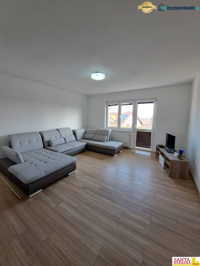 Living room in a 4-room apartment with a comfortable gray sofa and a floor with a wooden decor.