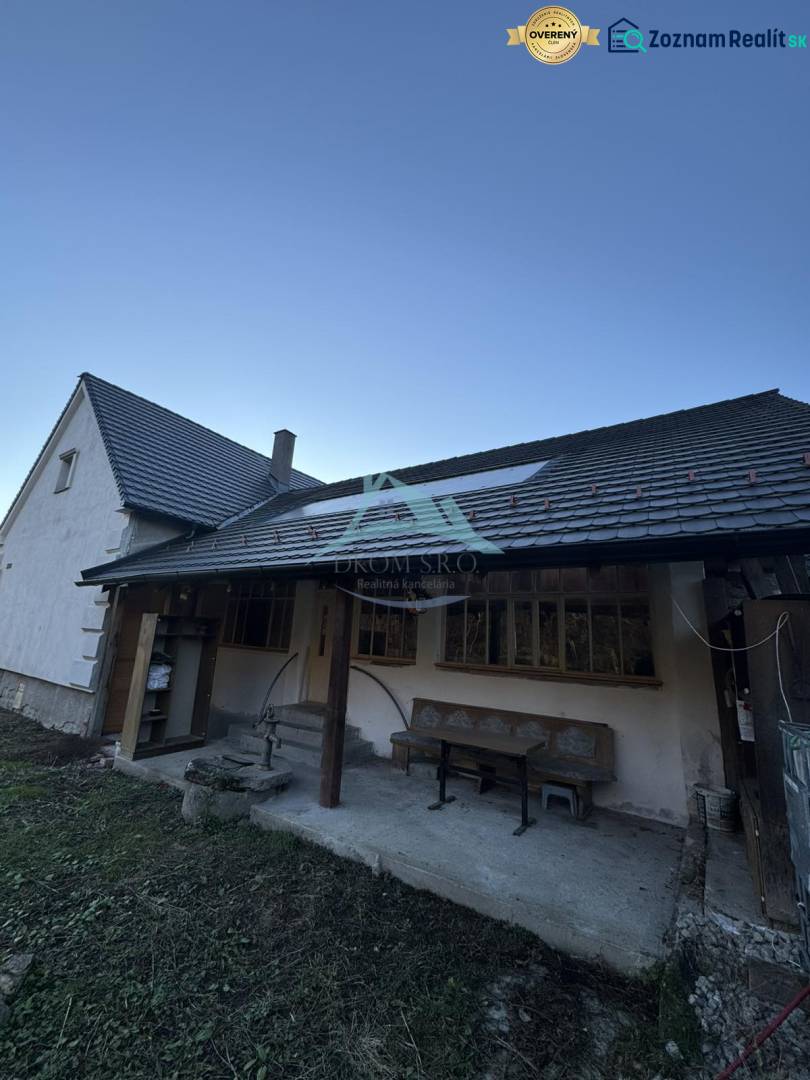 A family house in Demandice with a seating area in the yard and a gentle slope.