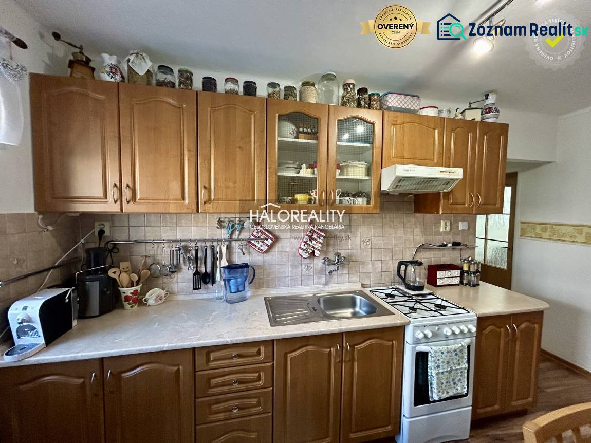 Kitchen in a 2-room apartment with wood decor on the floor and wooden cabinets.