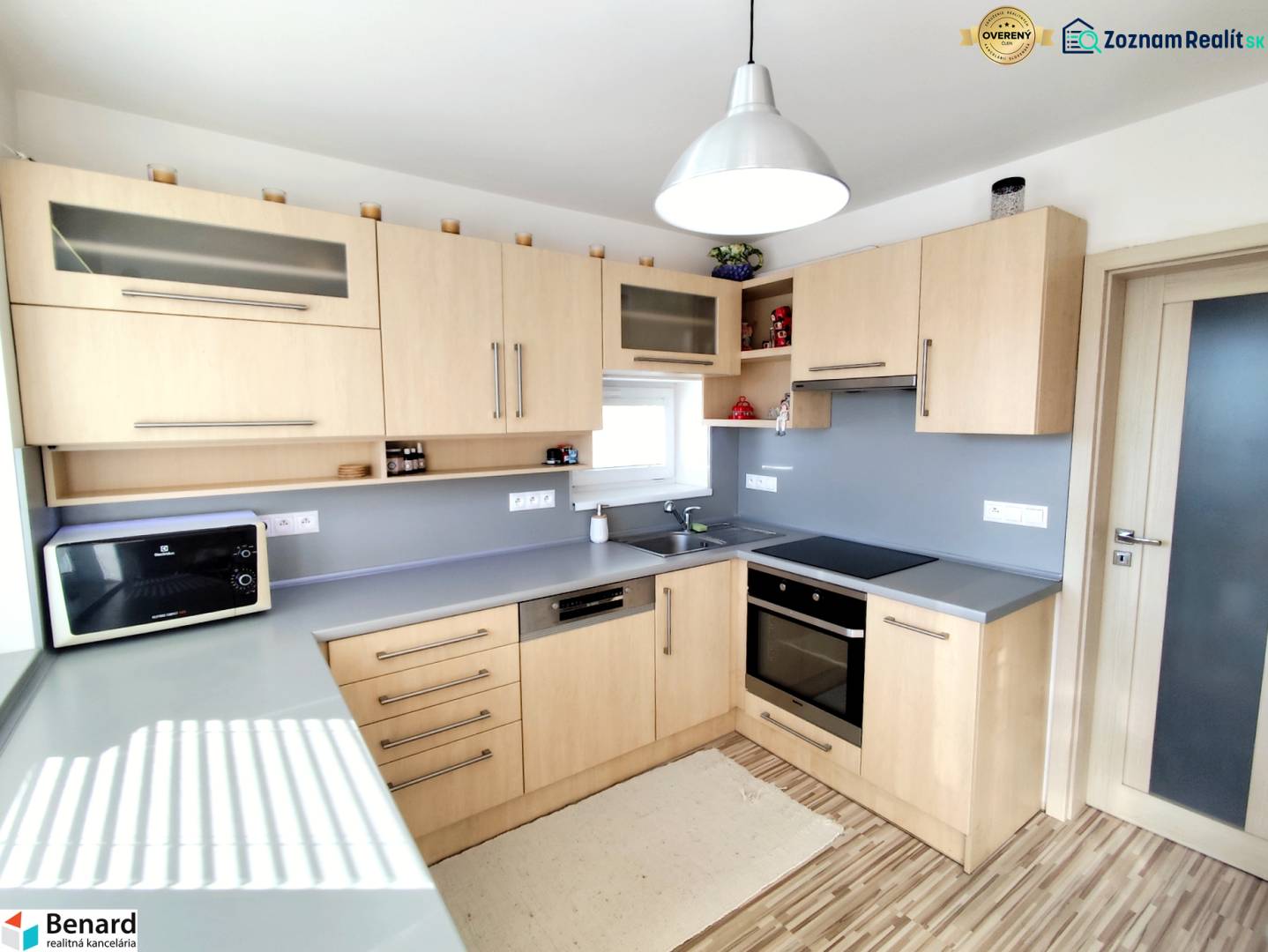 A kitchen in a family house with a wooden decor and a gray countertop.