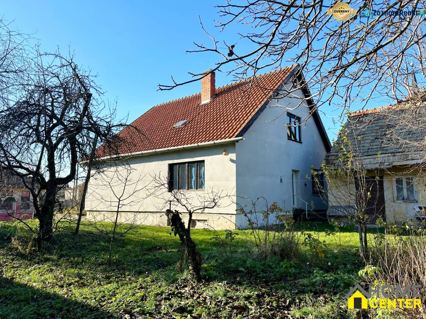 A family house in Iža on Podzáhradná Street with a red roof and a garden without leaves.