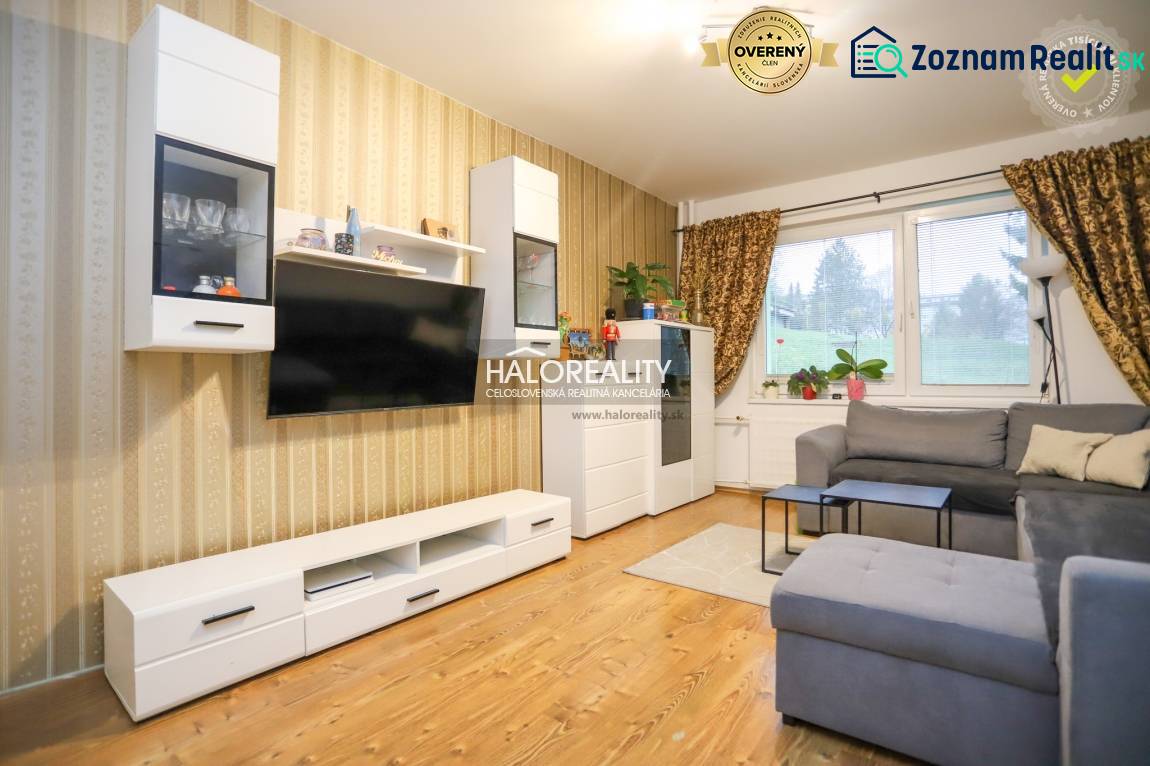 Living room in a two-room apartment with a wooden decor floor and a comfortable sofa.