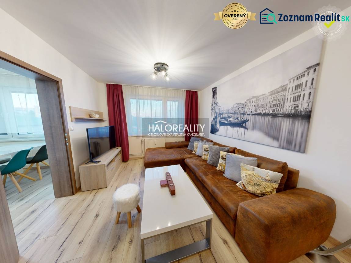 Living room in a two-room apartment with a brown sofa and a wooden decor floor.
