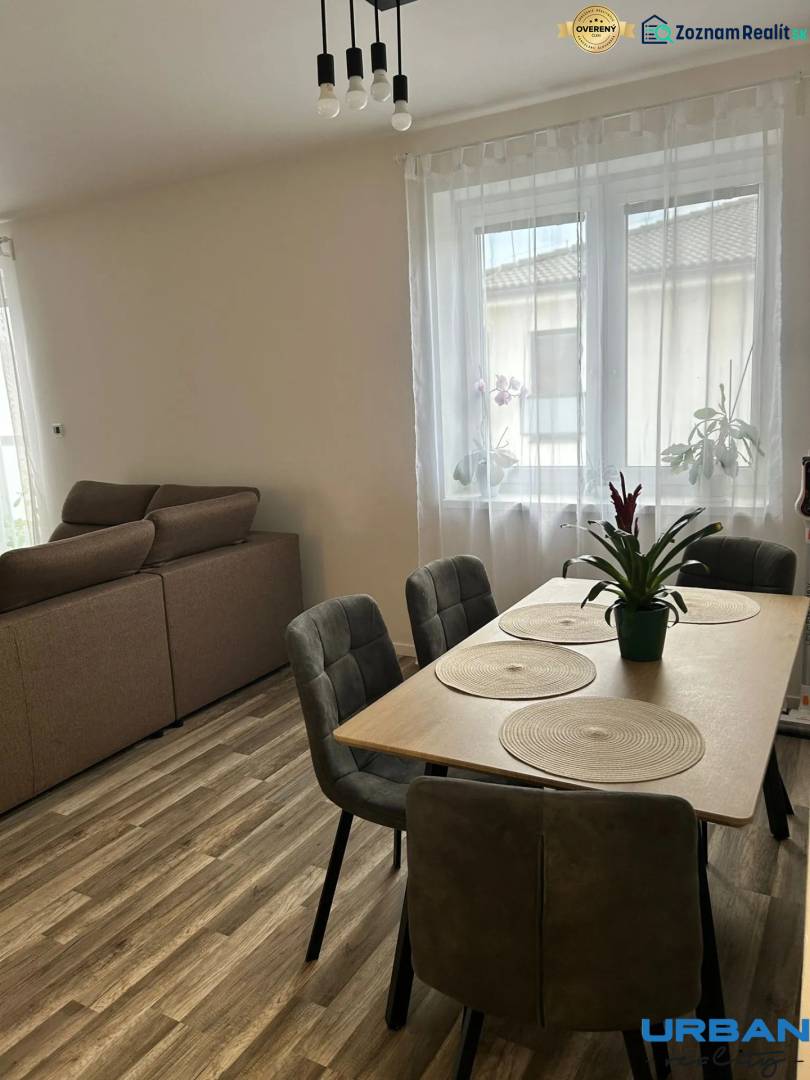 Dining table with chairs, floor with wooden decor, sofa in a 3-room apartment.