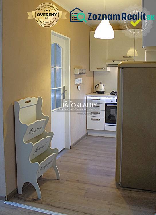 A kitchen in a 2-room apartment with a wooden decor floor and white appliances.