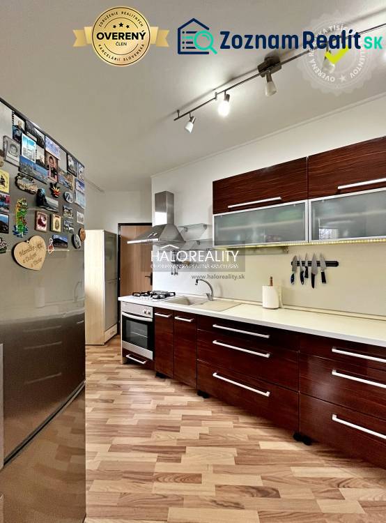 A kitchen in a 3-room apartment with a wood-patterned floor and appliances.