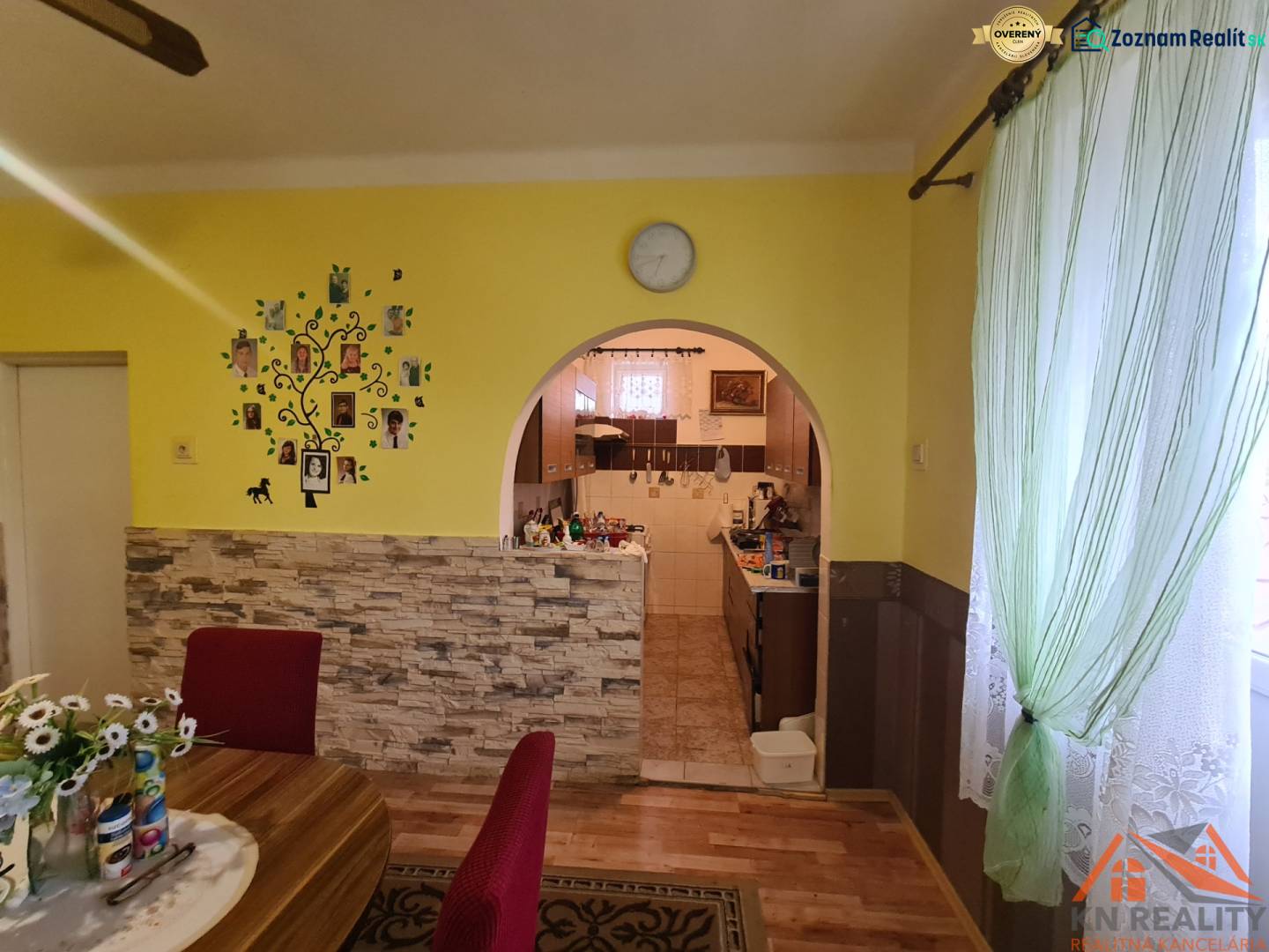 A dining room in a family house with an arched passage and a wooden decor floor.