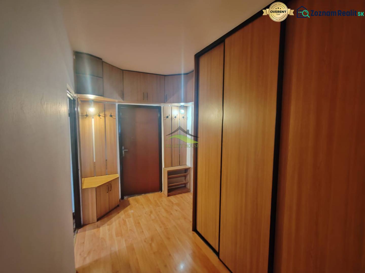 Entrance hallway in a 3-room apartment with a wooden decor floor and built-in wardrobes.