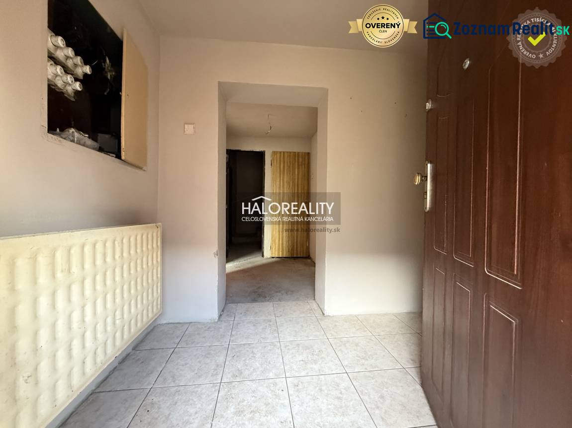 Entrance hallway of a family house with white tiles and brown doors.