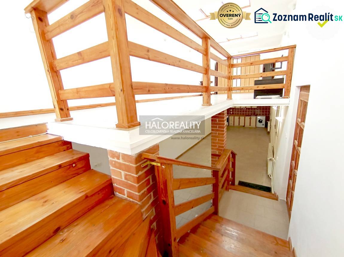 Wooden stairs and railings in a family house with a brick detail on the wall.