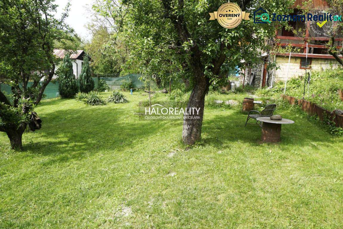 Garden and cottage with a gazebo, lawn, trees, table and chairs, ideal for relaxation.