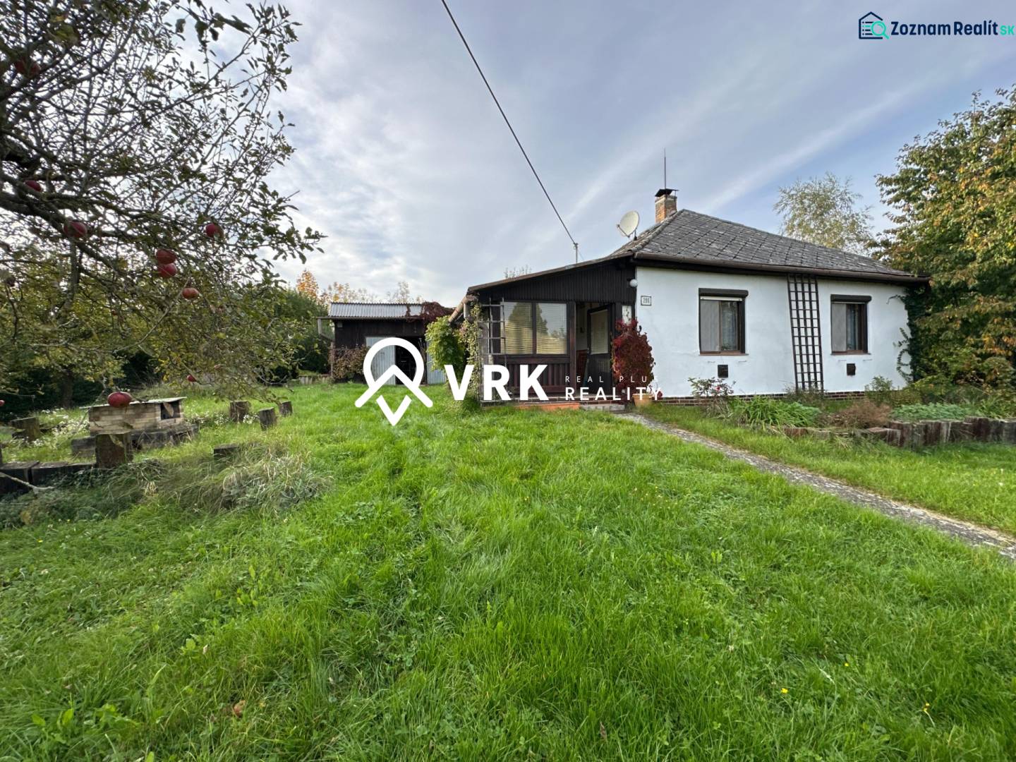 A family house in Kalša surrounded by a garden and fruit trees, with a manicured lawn.