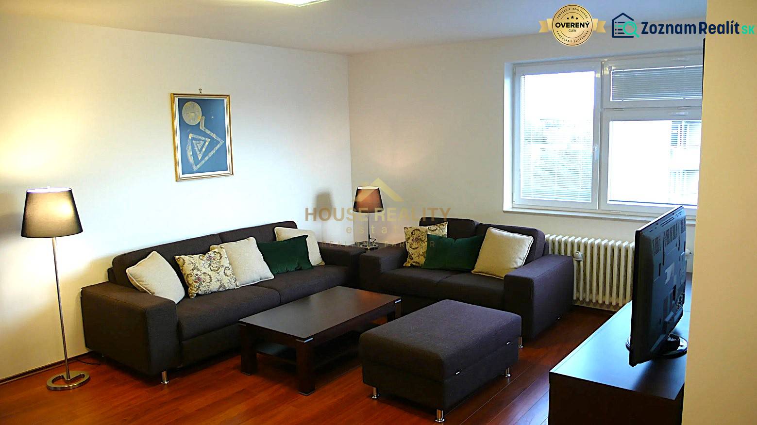 Living room in a 4-room apartment with sofas, TV, and wood-patterned flooring.