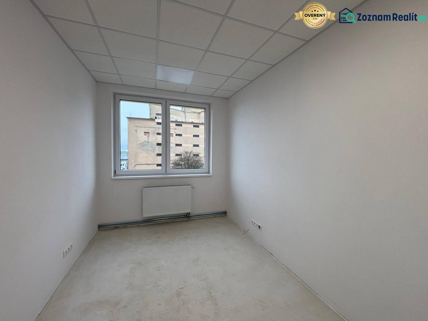 White office with a radiator and a view through the window.