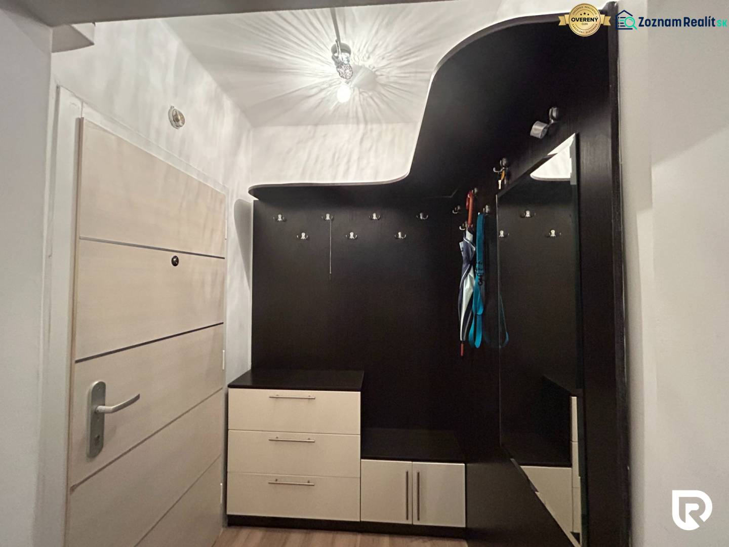 Entrance hall with practical furniture solution in a studio apartment with a wood-patterned floor.