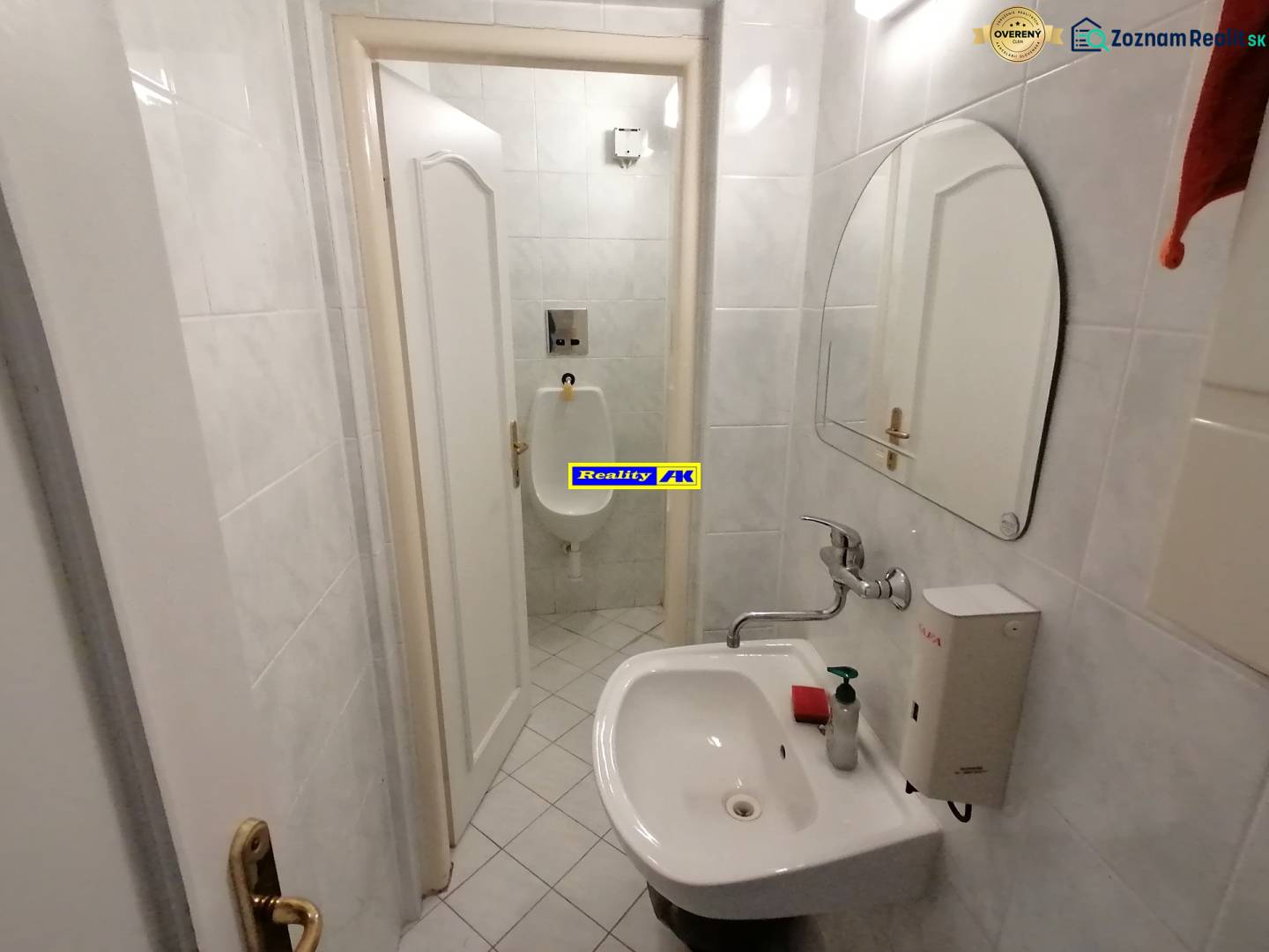 A small bathroom with a sink and a urinal in the offices.