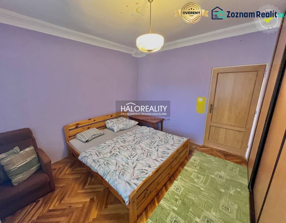 A bedroom in a 4-room apartment with a wooden decor floor and purple walls.