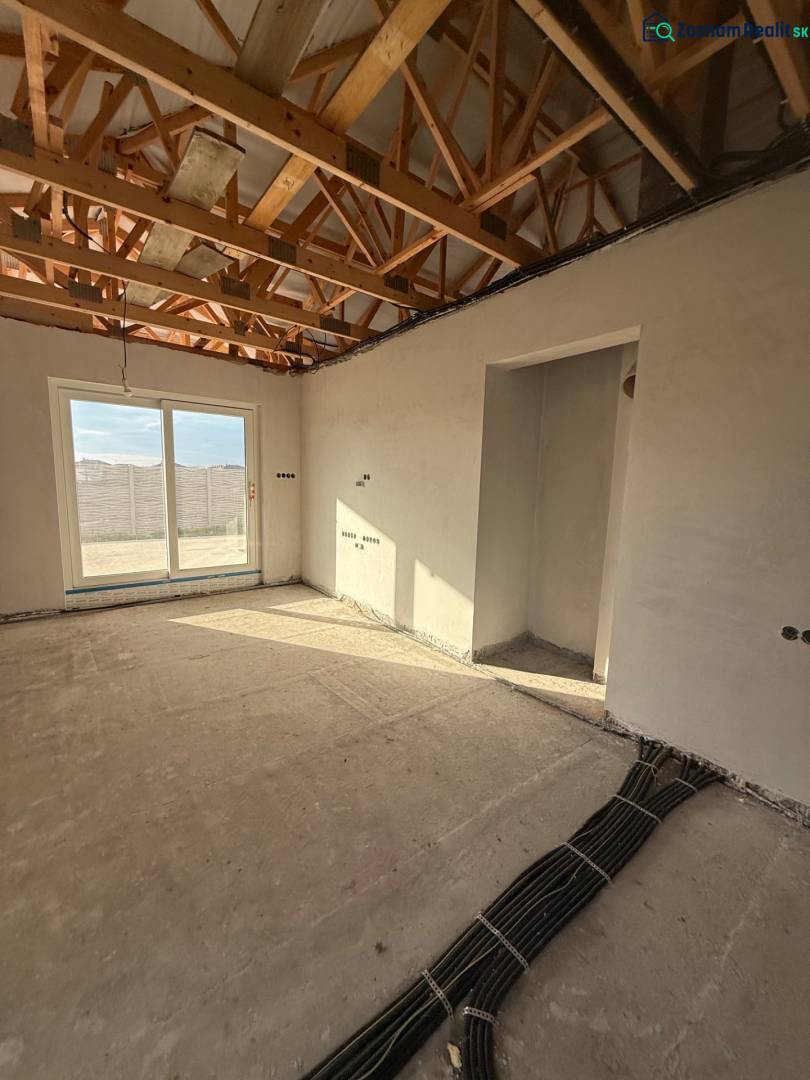 The interior of a family house with exposed ceiling beams and electrical installation preparation.