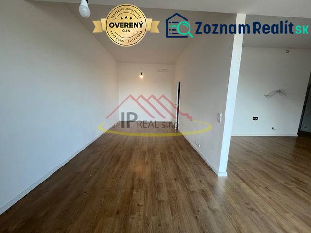 A room with a wooden decor floor in a 2-room apartment, neutral walls.