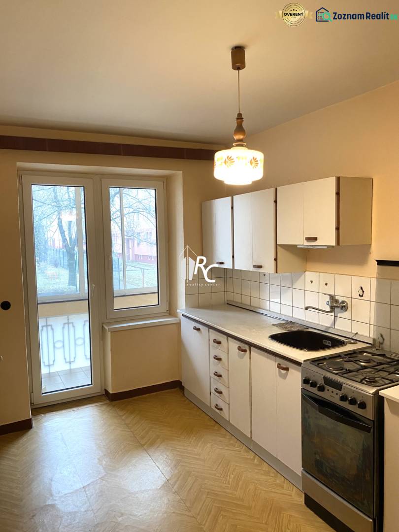 Kitchen in a 2-room apartment with a balcony, light, and a wooden decor floor.