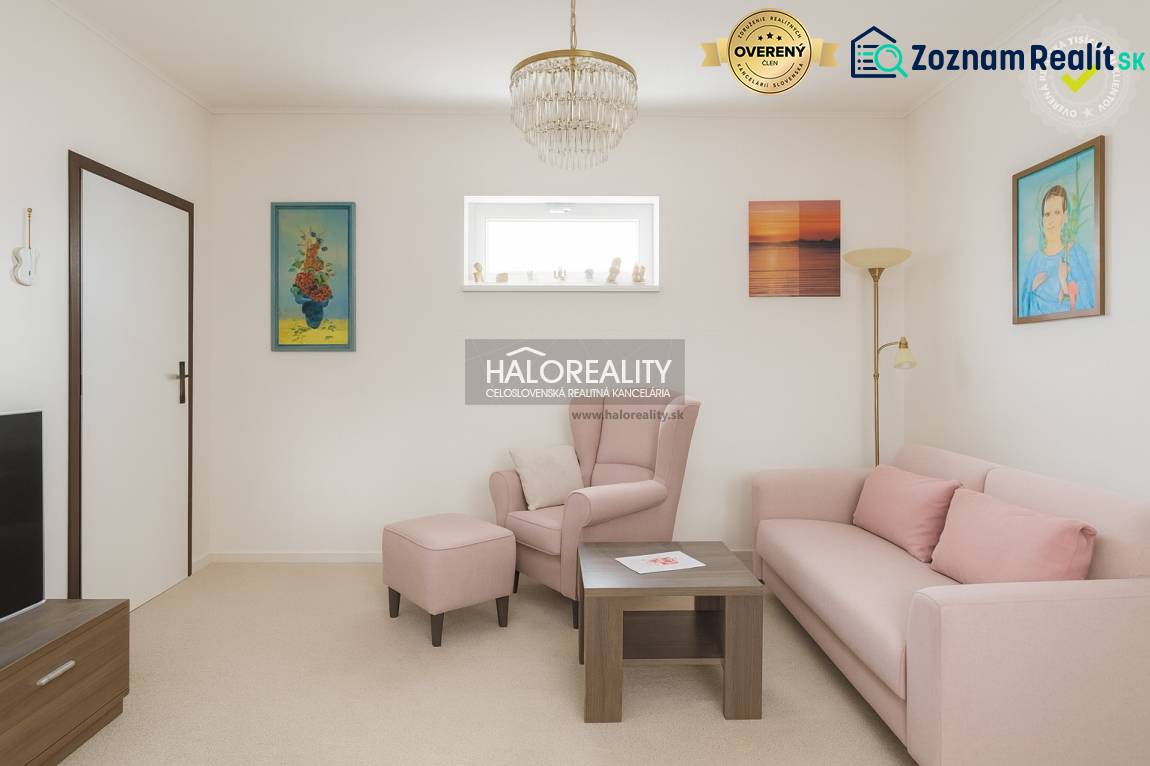 Living room with a pastel sofa and armchair in a family house, decorative paintings on the walls.