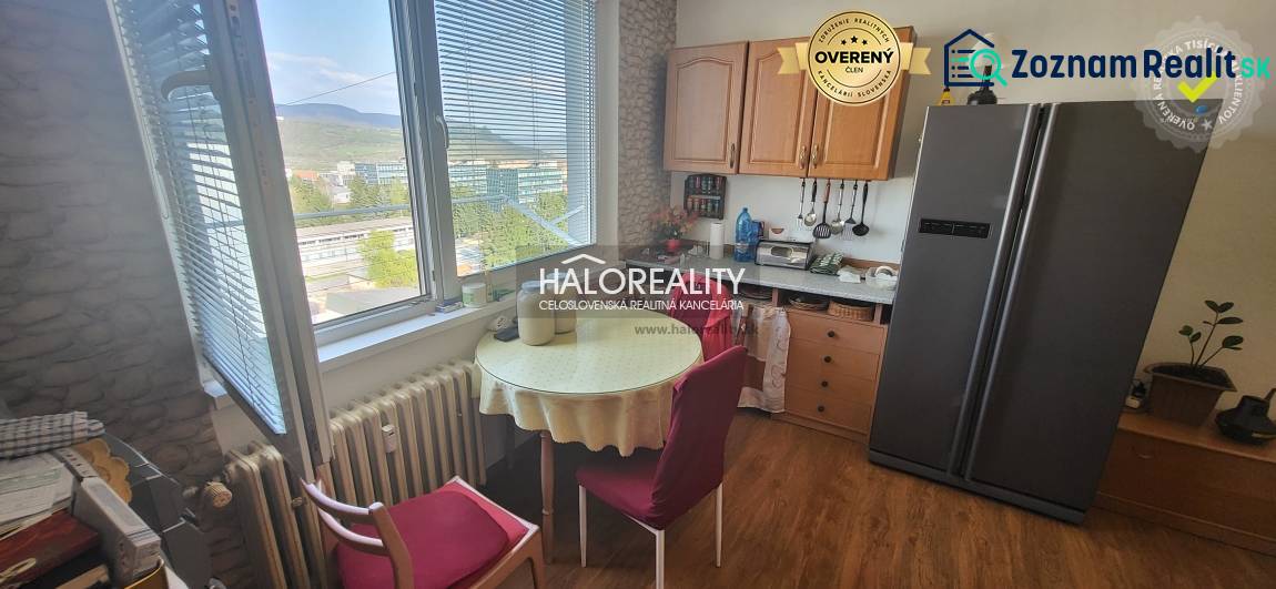 Kitchen in a studio apartment with a table, chairs, and a view from the window.