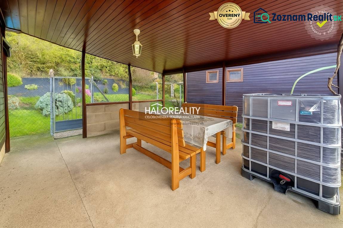 Covered terrace with a table, benches, and a view of the gardens in Bytča.