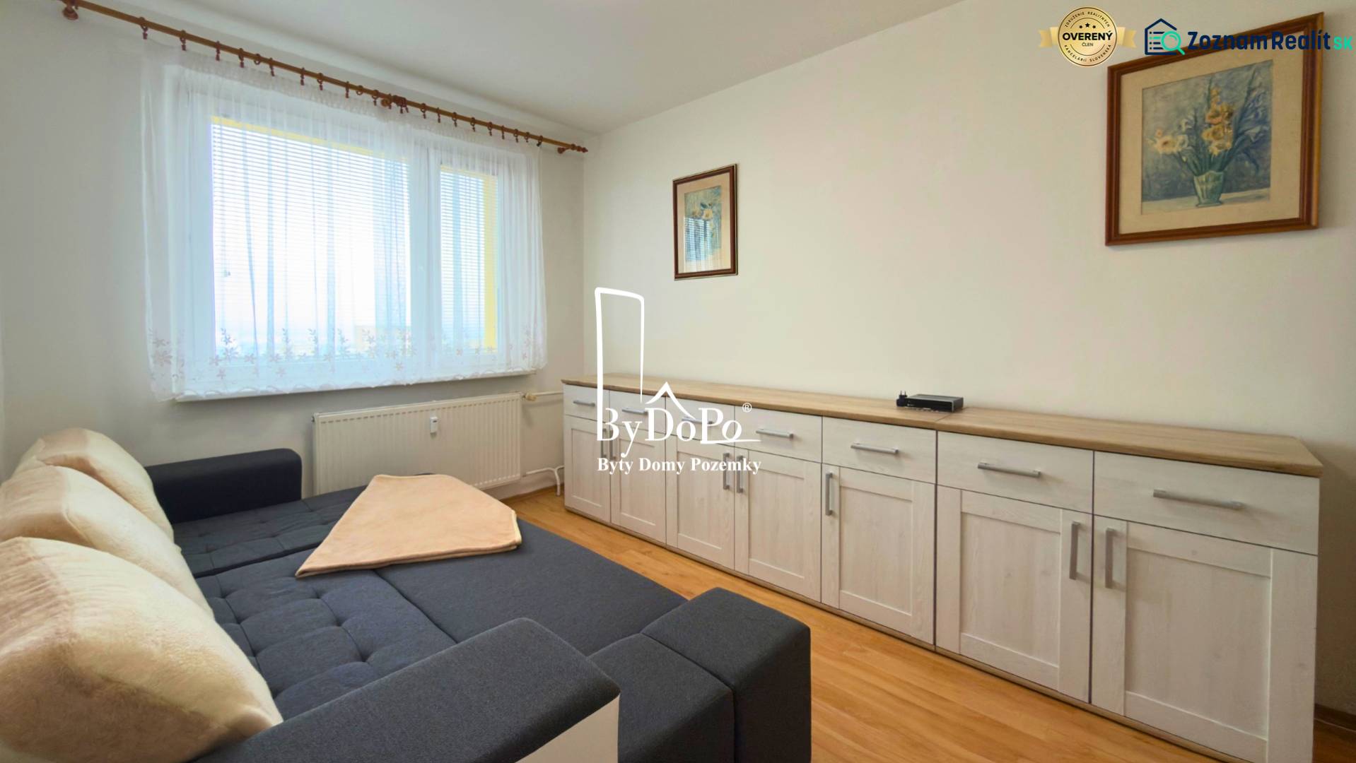 A room with a sofa, furniture, and a floor with wooden decor in a 3-room apartment.