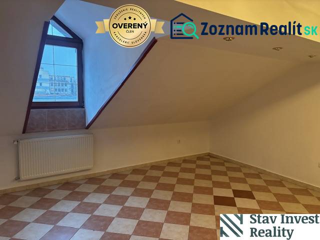 Attic office with tiles and a window, heated by a radiator.