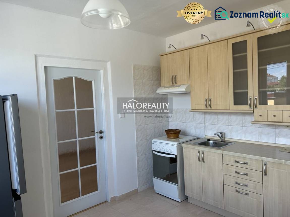 A kitchen with wooden decor, a tiled wall, a white stove, and white doors.