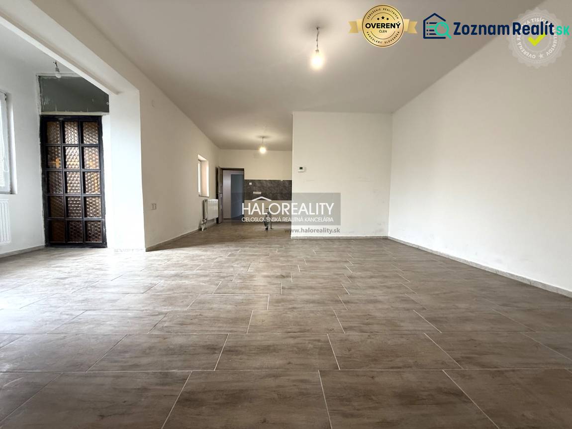 A spacious interior with large windows and wood-patterned flooring in a family house.