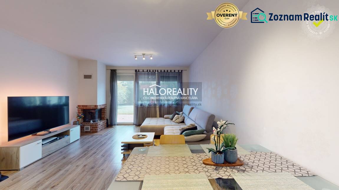 Living room with a fireplace, wooden decor flooring, and a dining table in a family house.