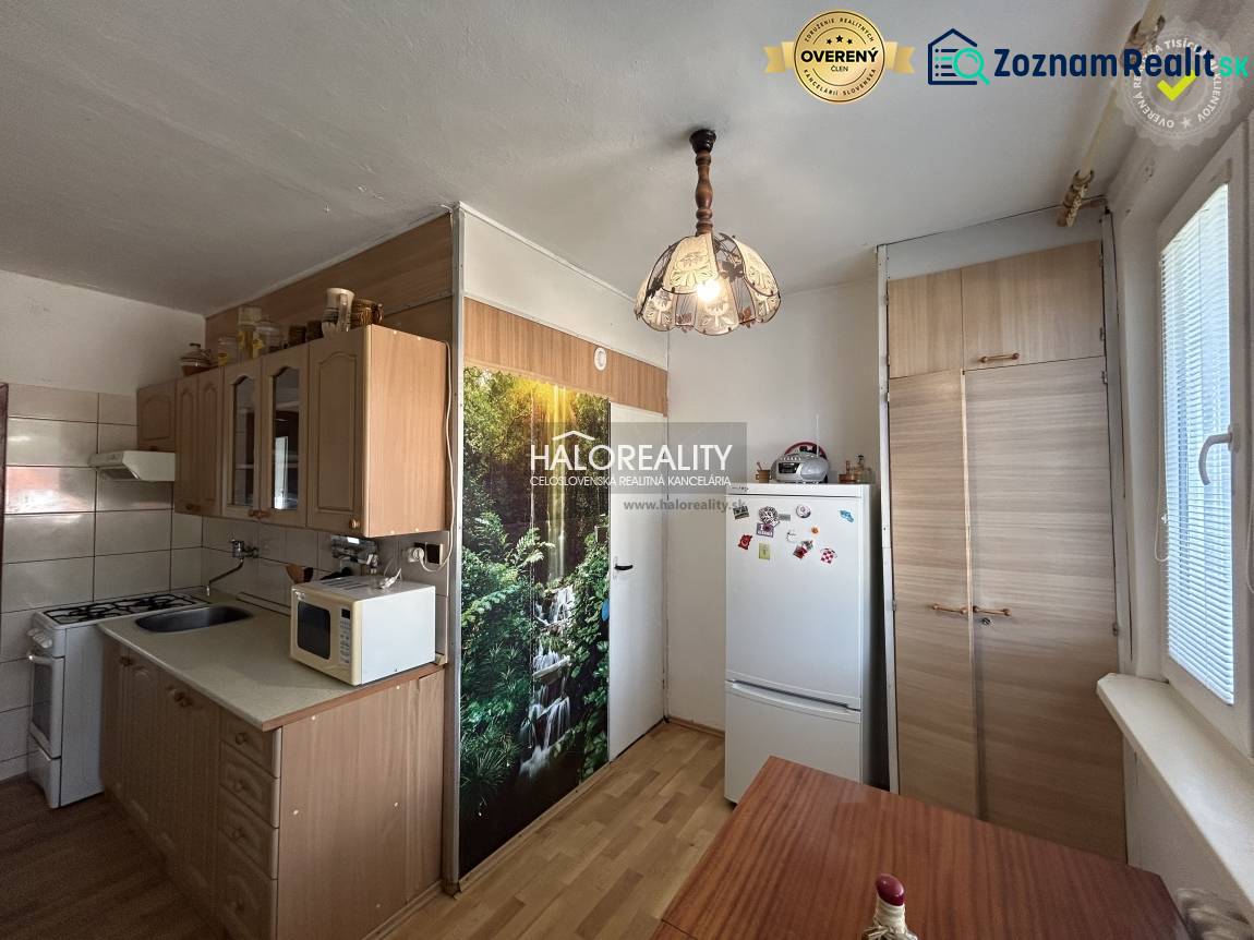 A kitchen unit with a wooden decor and a dining table in a 2-room apartment.