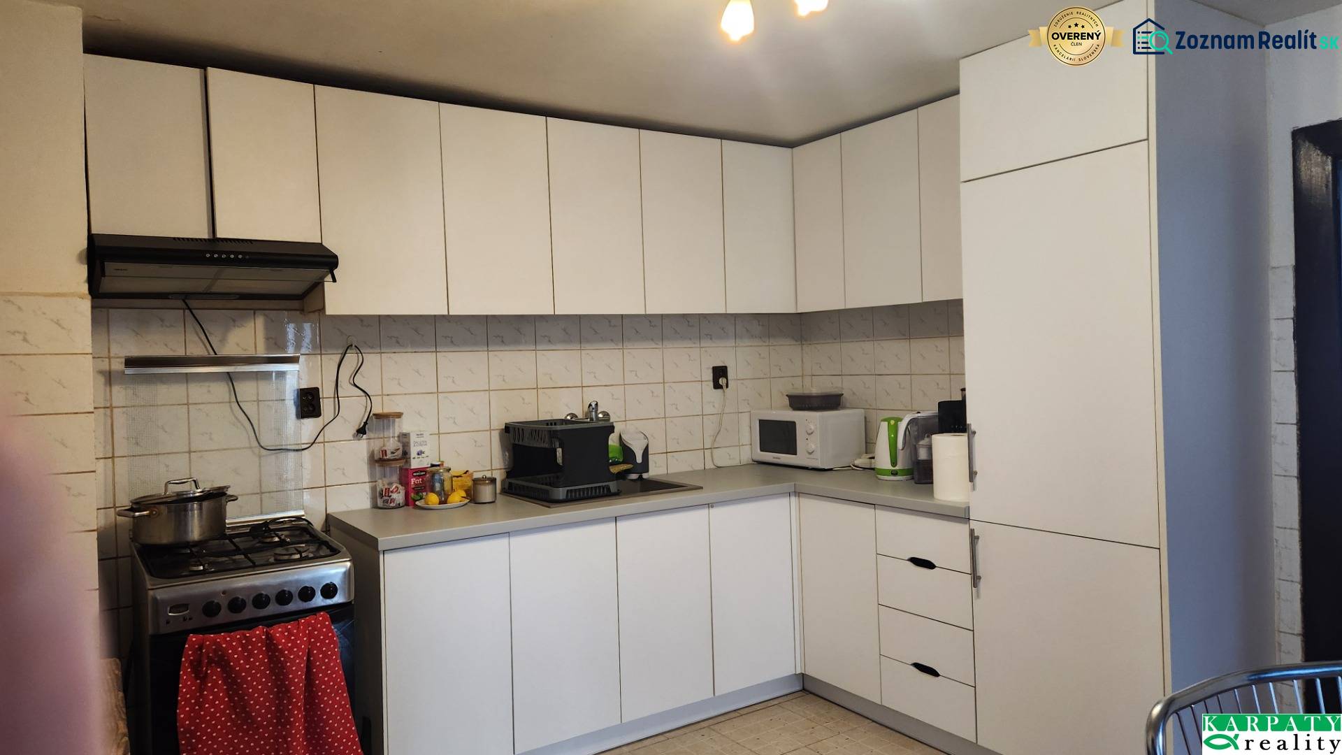 A kitchen in a family house with white cabinets, a stovetop, and a microwave.