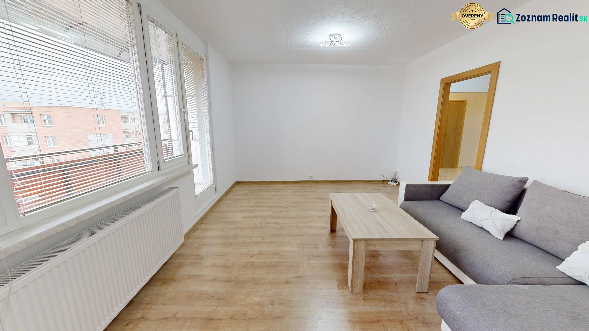 Living room with a gray sofa and a wooden decor floor in a 4-room apartment.